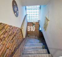 A staircase in a family house with brick cladding and a large window.
