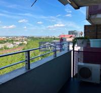 View from the balcony of a 1-room apartment over the cityscape, railway, and greenery.