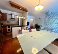 The kitchen and living room in a 3-room apartment with modern furniture and a decorative wall.