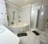 A bathroom in a 3-room apartment with a bathtub, shower, and sink.