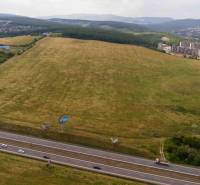 Extensive agricultural and forest lands in Košice, Luník IX district, with a highway.