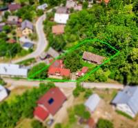 Aerial view of a family house in Púchov surrounded by green gardens and a street.