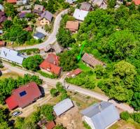 Aerial view of family houses and surroundings in Púchov, surrounded by greenery and roads.