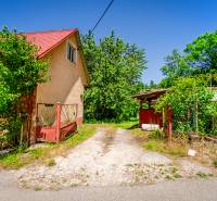 A family house on a street in Púchov, surrounded by greenery and an access road.