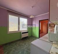 Kitchen in a studio apartment with a view, light wall, furnishings.