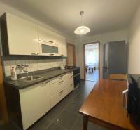 Kitchen in a 2-room apartment with a kitchenette, dining table, and appliances.