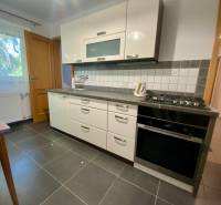 Kitchen in a 2-room apartment with white cabinets and black appliances.