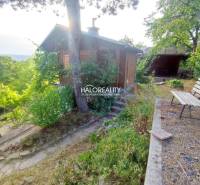 Gardens in Zvolen with a cottage, bench, and abundant greenery allowing for relaxation in nature.