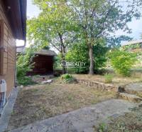 Wooden structures surrounded by grass and trees in gardens in the city of Zvolen.