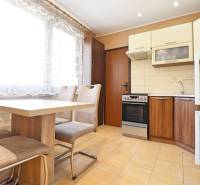 Kitchen in a 3-room apartment with a dining table and chairs, bright atmosphere.