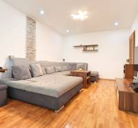Living room in a 3-room apartment with a comfortable sofa and wooden flooring.