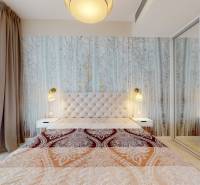 A bedroom with a patterned curtain, a mirrored wardrobe, and a lamp in a two-room apartment.