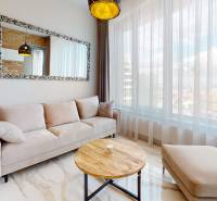 A bright living space with a comfortable sofa and a large mirror in a 2-room apartment.