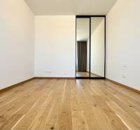 A room with a wooden floor and a mirrored wardrobe in a 2-room apartment.