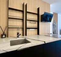 A kitchen unit with a marble countertop and open shelves in a two-room apartment.