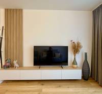 A bright living room in a 2-room apartment with a TV and decorations.