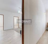 A corridor with access to rooms in a 3-room apartment, a table and chairs by the wall.