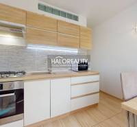 A kitchen in a 3-room apartment with wooden cabinets and a dining table.
