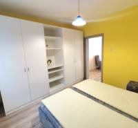 Yellow bedroom with a large white wardrobe in a 3-room apartment.