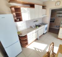 The kitchen of a 3-room apartment with white appliances and a kitchen unit.