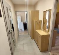 A hallway with a tiled floor and wooden furniture in a 3-room apartment.