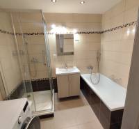A bathroom in a 3-room apartment with a shower and a bathtub, light tiles.