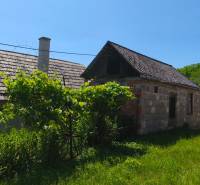 A family house in Čelovce with an extension and a garden, surrounded by greenery.