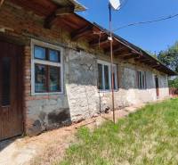 A family house in Čelovce with a stone facade and a green plot.