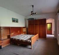 A bedroom with retro furniture and a bed in a family house.