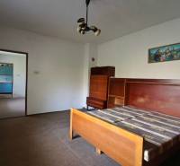 Bedroom with a wooden bed and wardrobe in a family house.