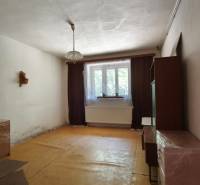 A room in a family house with furniture and a window, curtains complement the room.