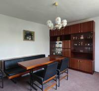 The dining room of a family house with wooden furniture and a chandelier in the interior.