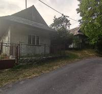 A family house in Čelovce with a stone fence and a rural atmosphere on a quiet street.