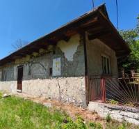 A family house in Čelovce with an older facade, lawn, and iron fence.
