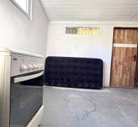 White room in a cabin with a kitchen stove and wooden door.
