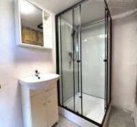 Bathroom in a cabin with a sink and a shower on a light-colored floor.