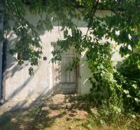 An older family house on Mostová Street in Sečovce, surrounded by greenery and trees.