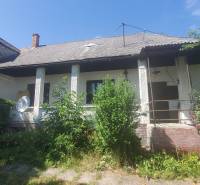A family house on Mostová Street in Sečovce, with lush vegetation in front of the house.