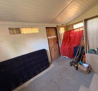 A room with cabinets, tools, and a red cloth on the wall, looks like a storage space.