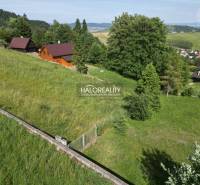 Recreational plots in Vyšné Ružbachy with wooden cottages surrounded by greenery and hills.