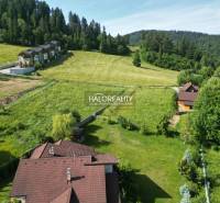 Recreational plots in Vyšné Ružbachy surrounded by greenery and forests on the hillside.