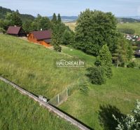 Recreational plots in Vyšné Ružbachy with wooden cottages surrounded by greenery and hills.