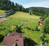 Recreational plots in Vyšné Ružbachy surrounded by greenery and forests on the hillside.