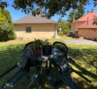 The garden of a family house in Slovenská Kajňa with a plastic table and chairs.