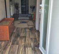 Entrance hallway of a family house with a wooden floor, shoe cabinet, and open doors.