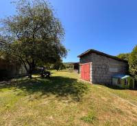 The garden of a family house in Slovenská Kajňa with a shelter and a tree.