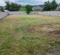 A plot of land with a lawn surrounded by a fence on Nezabudova Street in Sabinov, ideal for a family house.