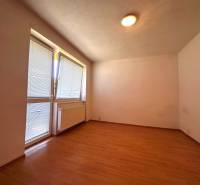 A room with a wooden floor, a radiator, and a window with blinds in a 3-room apartment.