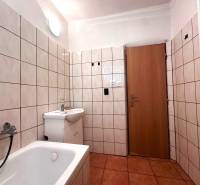 A bathroom with a bathtub and a sink in a 3-room apartment.