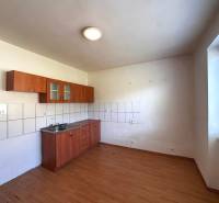 A kitchen in a 3-room apartment with a sink, tiles, and wooden flooring.